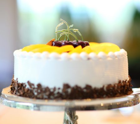 Elegant cake with fruits and chocolate shavings, perfect for celebrations.